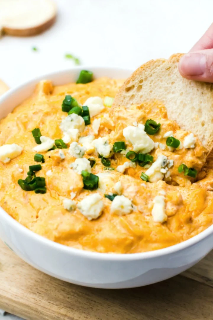 This Crockpot Buffalo Chicken Dip recipe makes a warm, spicy cheese dip using rotisserie chicken. One of the best game day appetizers for a football party, this easy dip recipe is a low carb dip, too! #buffalochickendip #rotisseriechicken #gamedayappetizers crockpot buffalo chicken dip