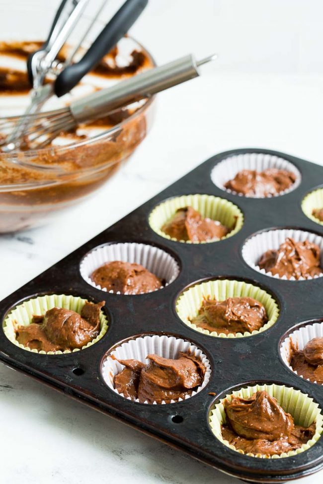 Muffin tin filled with chocolate pumpkin batter