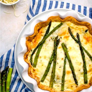 fresh asparagus quiche in white scallop-edge pie dish