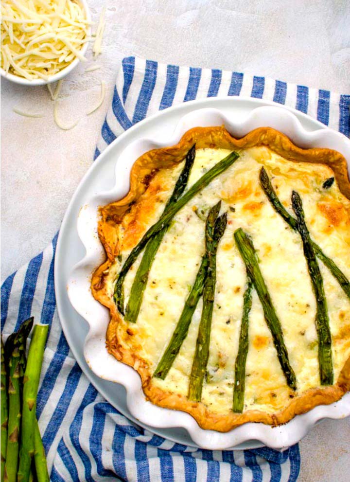 fresh asparagus quiche in white scallop-edge pie dish