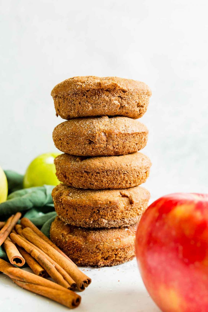 A side view of a stack of five cinnamon sugar coated apple cinnamon donuts.