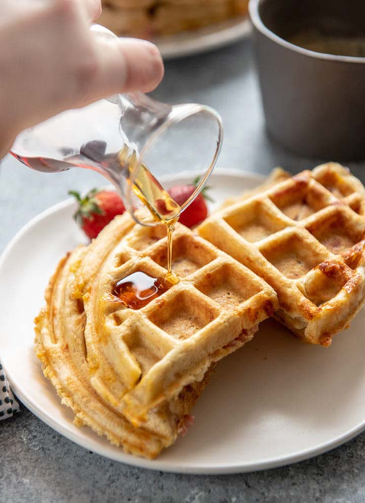 pouring syrup onto homemade ham stuffed waffles