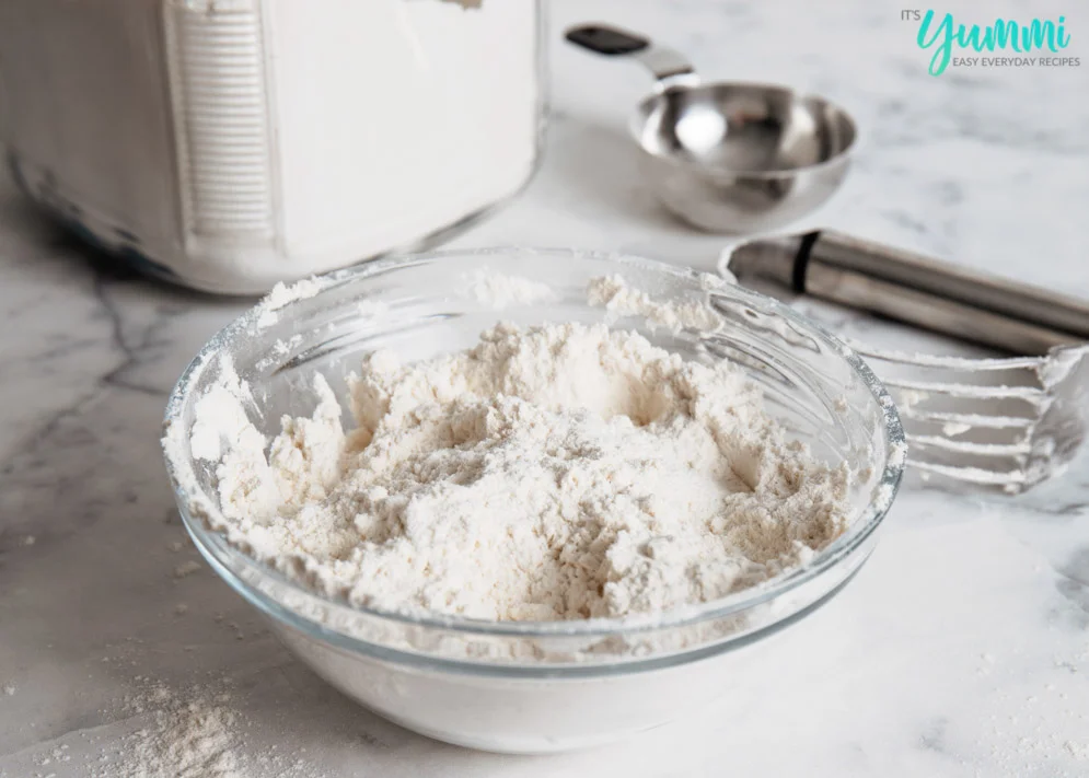 Bowl of DIY Bisquick with dough cutter and measuring cup in background