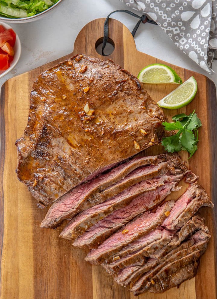 slices of juicy pan seared steak on wooden cutting board