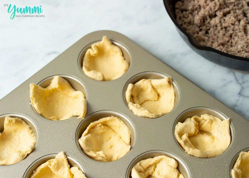 Biscuit Dough Pressed into muffin tin as the base for cheesy sausage biscuits