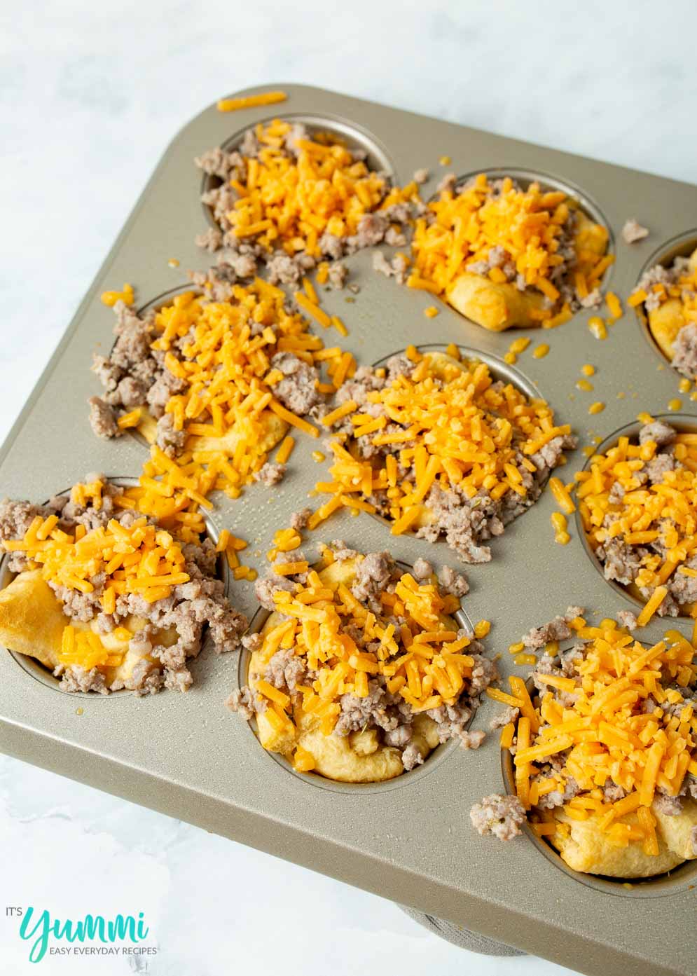 Cheesy Sausage Biscuits in Muffin tin before baked.