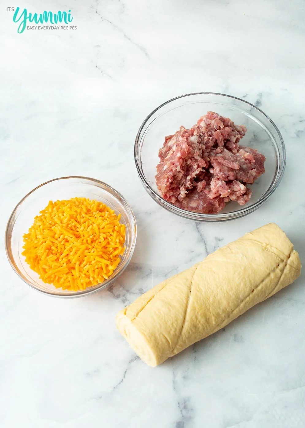 Ingredients for Sausage Biscuits (cheese, sausage and dough)laid out on table