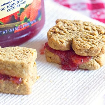 Low Sugar Peanut Butter and Jelly Sandwich Cookies - Healthy snack ideas start with these adorable sandwich cookies! They're filled with sugar-free jelly and shaped to look like a real peanut butter and jelly sandwich! Get the recipe from itsyummi.com