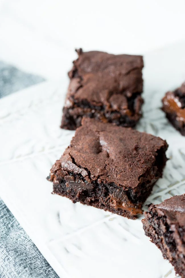 best ever brownies with chocolate chunks on a white platter