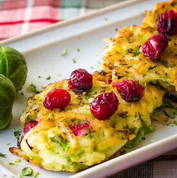 hash brown potato pancakes topped with fresh cranberries and shaved Brussels sprouts