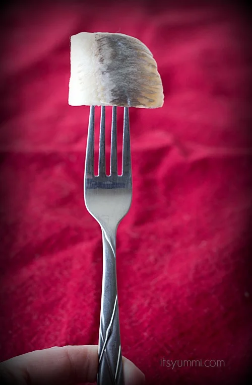 old fashioned pickled herring on a fork