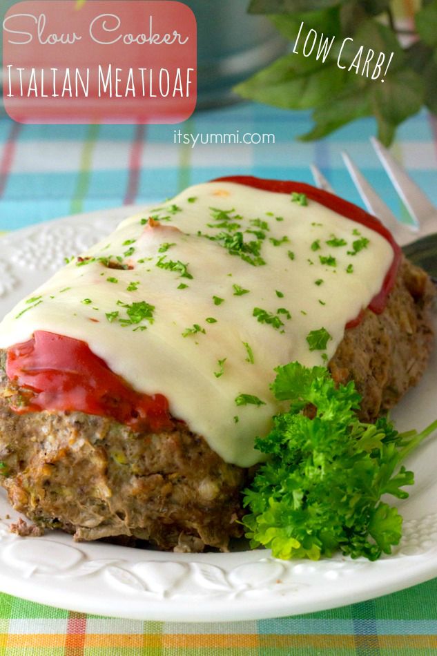 This low carb meatloaf recipe is made w/ lean ground beef and a healthy hack substitute for bread crumbs. Our best healthy slow cooker recipe for meatloaf! #crockpot #lowcarb #healthyhacks #slowcooker Low Carb Italian Meatloaf made in a slow cooker sits on a white platter, garnished with fresh parsley