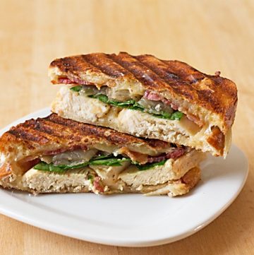 Cheesy Grilled Chicken Panini Sandwich - Crispy bacon, caramelized onions, baby spinach, and lots of cheese, grilled up between layers of 3-cheeses sourdough. Recipe from @itsyummi