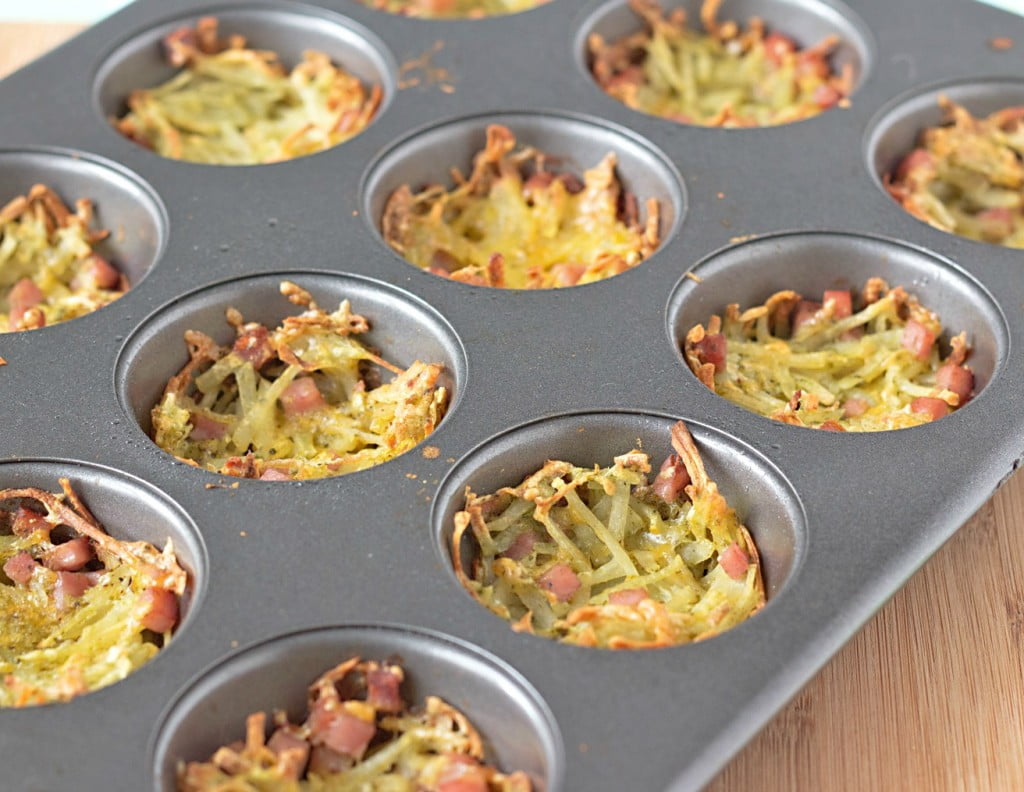 muffin tin filled with ham and cheese hash brown potato nests