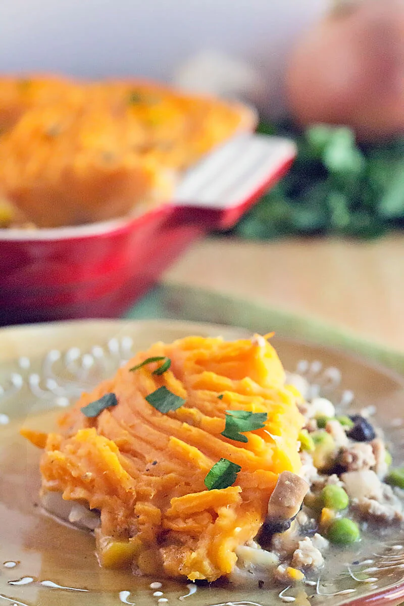Sweet Potato Shepherds Pie Casserole - ground turkey and fresh vegetables cooked in gravy, topped with mashed sweet potatoes. This easy shepherd's pie recipe is a 30 minute meal. Perfect as a St. Patrick's Day dinner recipe and great use for Thanksgiving leftovers! #veggies #turkey #casserole #recipe #StPatricksDay #Thanksgiving one serving of sweet potato shepherd's pie on a beige dinner plate