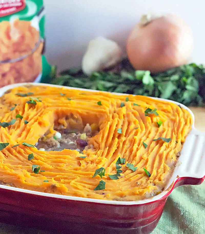 Sweet Potato Shepherds Pie Casserole - ground turkey and fresh vegetables cooked in gravy, topped with mashed sweet potatoes. This easy shepherd's pie recipe is a 30 minute meal. Perfect as a St. Patrick's Day dinner recipe and great use for Thanksgiving leftovers! #veggies #turkey #casserole #recipe #StPatricksDay #Thanksgiving red square casserole dish with sweet potato shepherd's pie