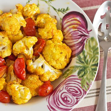 Indian Spiced Roasted Vegetables recipe - cauliflower, grape tomatoes and white cannellini beans are seasoned with tumeric, sweet paprika, and cumin. A great vegetarian dish for meatless Monday or as a side with chicken or lamb!