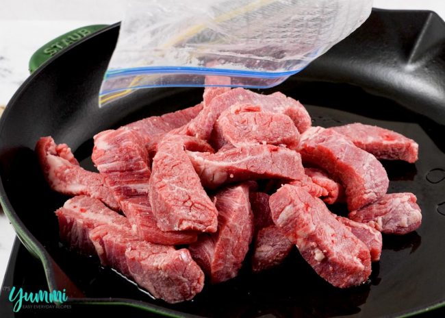 Coated Beef Strips being added to a hot skillet