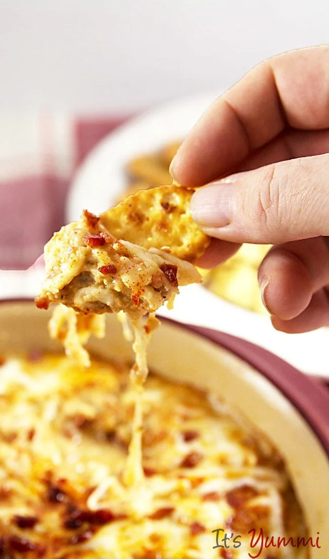 Clams casino dip is one of the best appetizers, especially for holiday entertaining. This dip recipe is a take on baked clams. #clamdip #clamscasino #bestappetizers clams casino dip on a buttery cracker