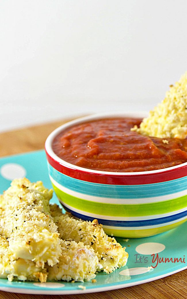 homemade mozzarella sticks recipe - dipping into marinara sauce