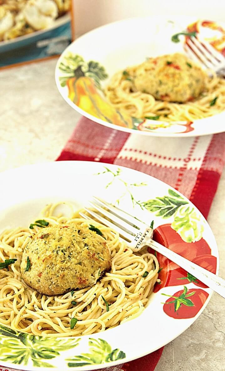 Crab Cake Scampi - This is a perfect recipe for lent! Flaky, tender crab cakes (sustainably harvested) sit on top of a bed of garlic-butter pasta. So easy to make! Get the recipe from itsyummi.com