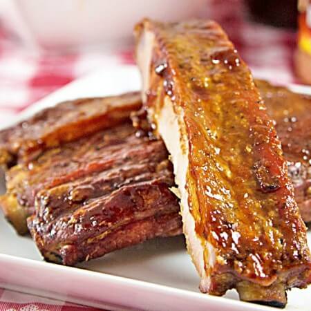Cajun-Spiced Smoked Spare Ribs Recipe from ItsYummi.com - This recipe has an option for smoking the ribs with a smoker or baking them in an oven. They're dry rubbed first and then finished off with a tangy Louisiana style barbecue sauce.