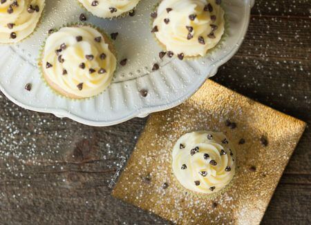 Cannoli cupcakes are inspired by the popular Italian dessert. Moist cinnamon cupcakes, topped with fluffy mascarpone buttercream and a sprinkling of chocolate chips and powdered sugar. Recipe on itsyummi.com