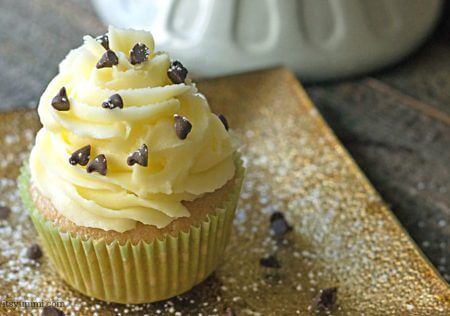 Cannoli cupcakes are inspired by the popular Italian dessert. Moist cinnamon cupcakes, topped with fluffy mascarpone buttercream and a sprinkling of chocolate chips and powdered sugar. Recipe on itsyummi.com