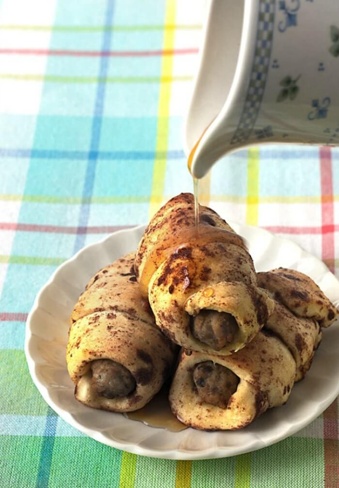 Cinnamon roll bundles stuffed with maple breakfast sausage, drizzled with maple syrup