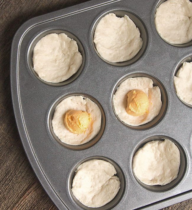 buttermilk biscuit dough with scoops of pimento cheese inside, ready to be baked