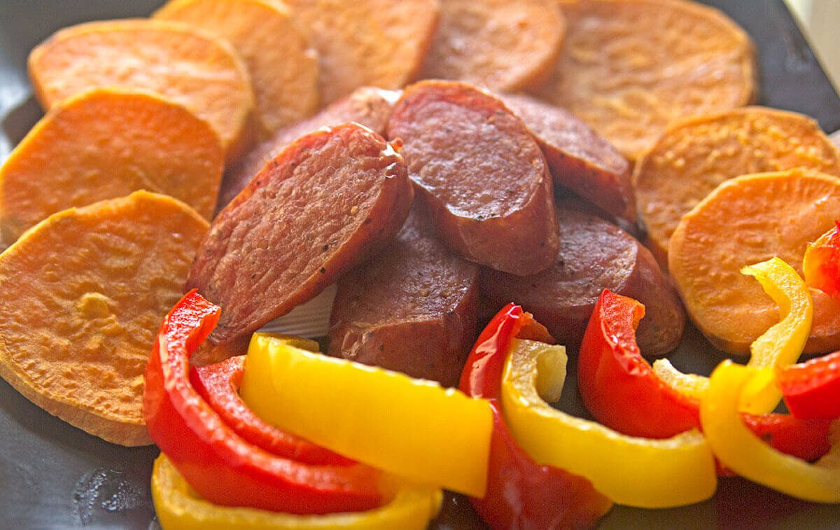 This easy sausage sheet pan dinner is a delicious and quick weeknight meal! Smoked sausage, sweet potatoes, and bell peppers are lightly seasoned, then roasted for 20 minutes in this one pan dinner recipe.