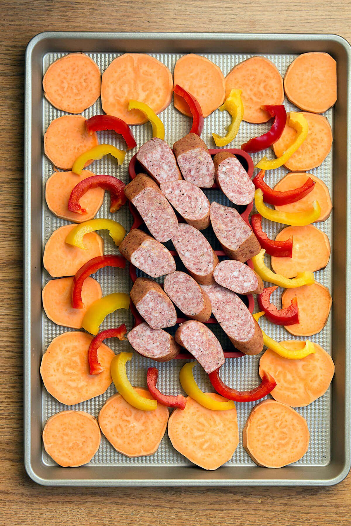 This easy sausage sheet pan dinner is a delicious and quick weeknight meal! Smoked sausage, sweet potatoes, and bell peppers are lightly seasoned, then roasted for 20 minutes in this one pan dinner recipe.