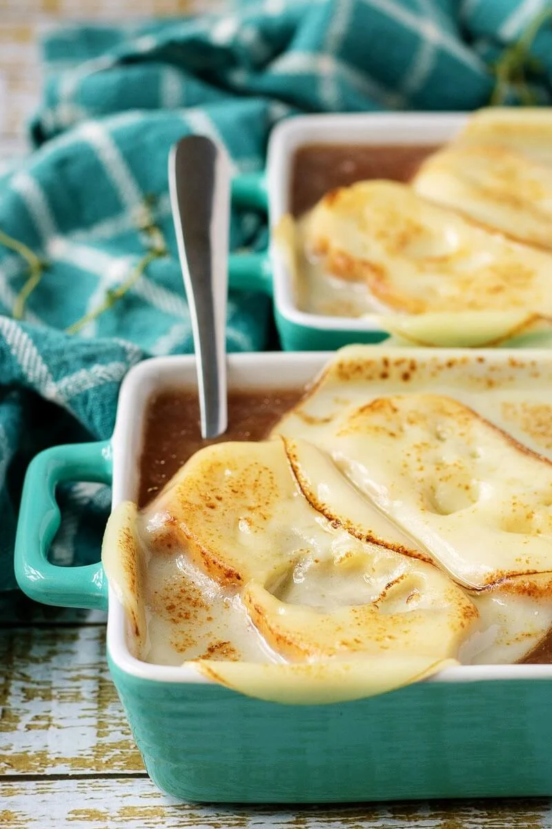 Photo of a soup crock full of French onion soup with melted cheese on top