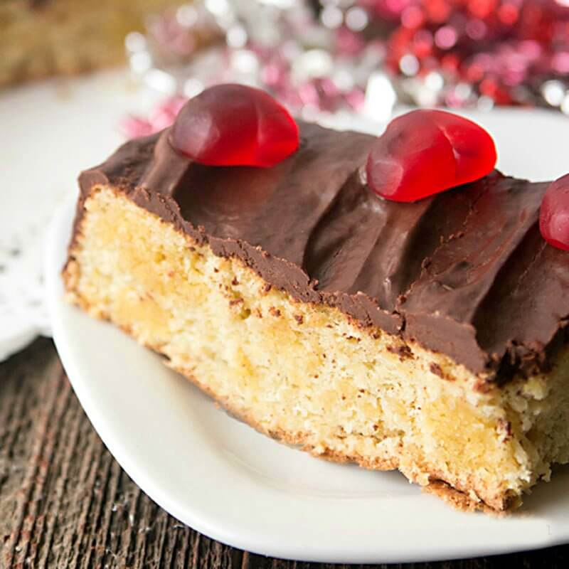 Chocolate almond flour cake baked in a cute heart shaped cake pan makes the perfect Valentine's Day dessert! This heart shaped cake is a low carb chocolate cake, made with almond flour and covered with sugar-free chocolate ganache. A Valentine's Day dessert with NO REFINED SUGAR. #lowcarb #valentinesday #cake #dessert #chocolate #recipe slice of chocolate almond flour cake with low carb chocolate ganache