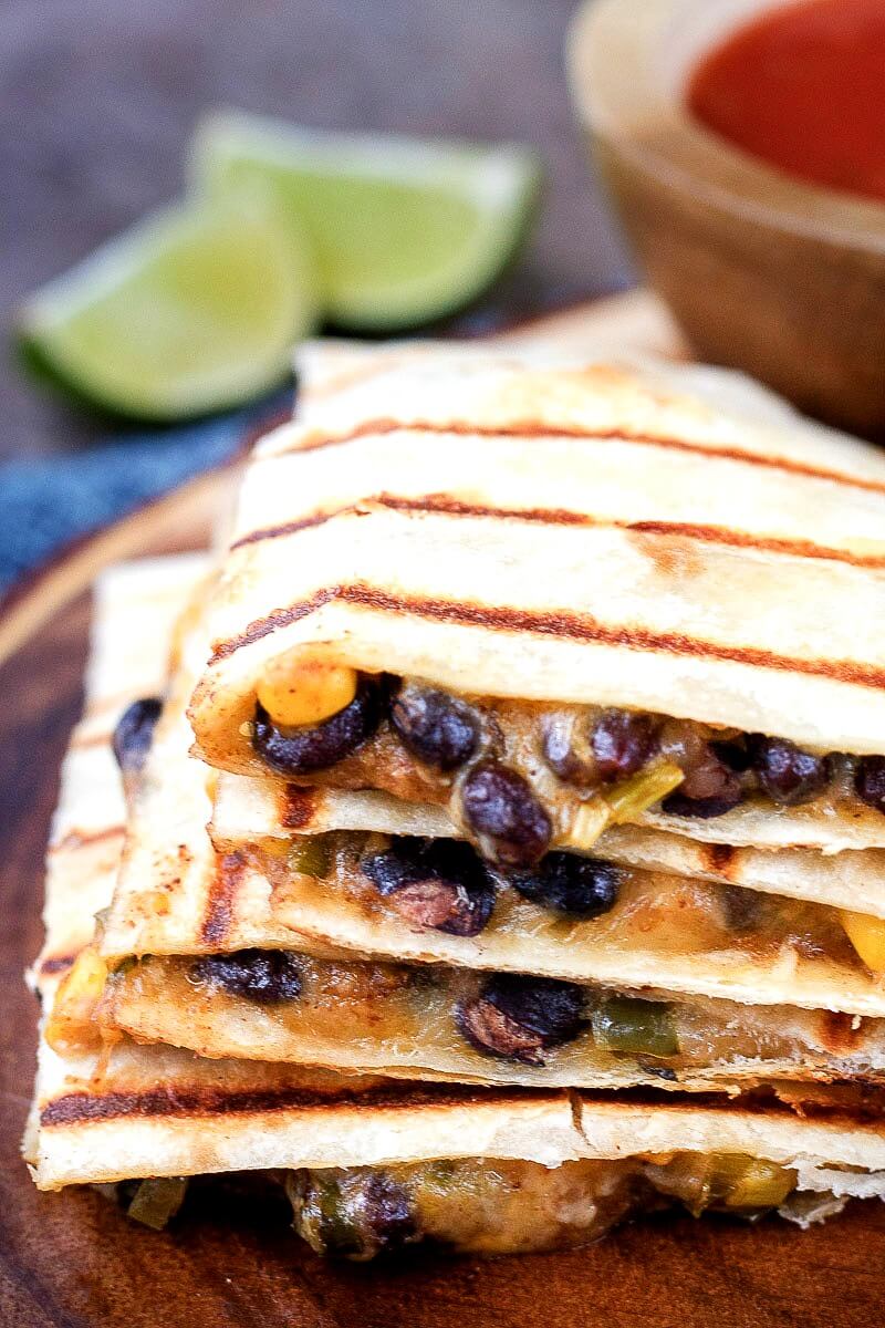 Vegetarian quesadillas will be a welcome entree for a meatless Mexican dinner or lunch. Each quesadilla is stuffed with a spicy corn and black bean mixture and cheese.This quesadilla recipe is ready to eat in 20 minutes. Includes Weight Watcher's friendly options - substitutions noted in the recipe. #Mexican #WeightWatchers #recipe #quesadilla #appetizer #vegetarian #meatless stack of Southwest vegetarian quesadillas filled with spicy corn and black bean mixture