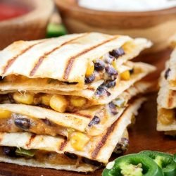 close up square image of vegetarian quesadillas filled with spicy black beans, corn, and cheese