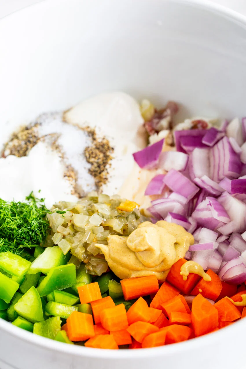A close up process shot making potato salad with farm fresh veggies