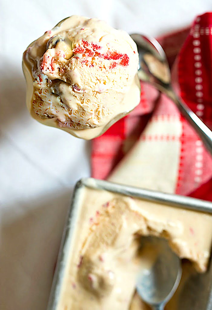 sundae dish of strawberry cookie dough ice cream next to a container of the homemade ice cream