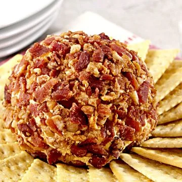bacon covered chipotle cheddar cheese ball surrounded by crackers