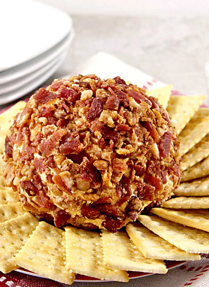 bacon covered chipotle cheddar cheese ball surrounded by crackers