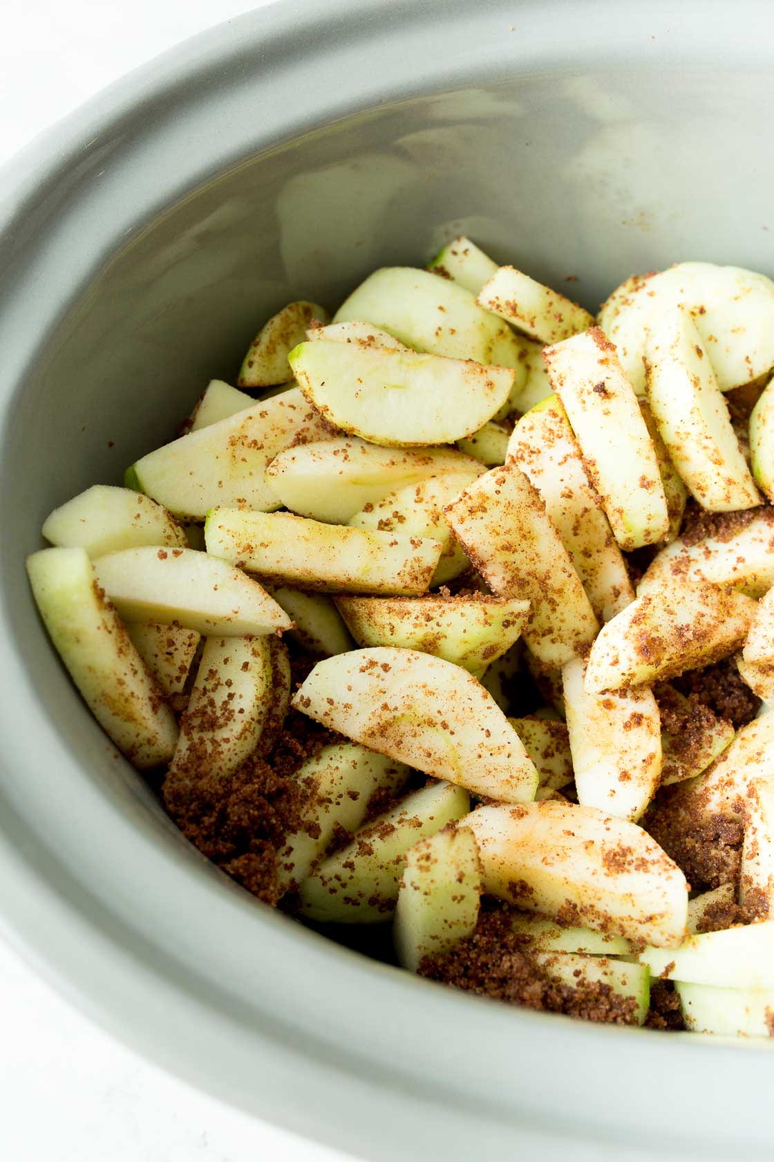 Sliced apples in slow cooker before cooked