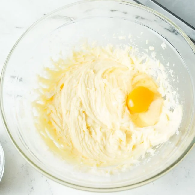 A glass bowl of smoothed butter, sugar, and egg.
