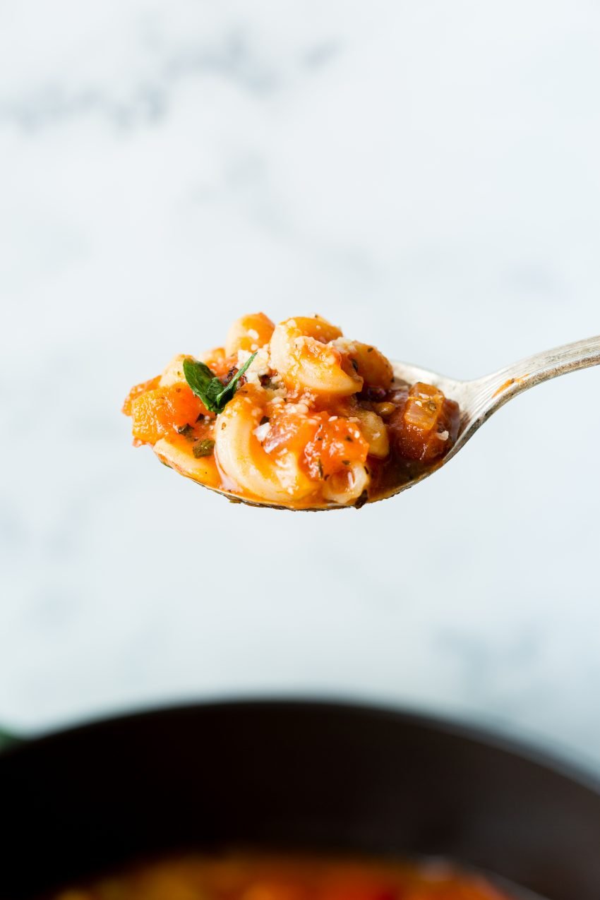 A close up image of a spoonful of vegetarian minestrone soup. 