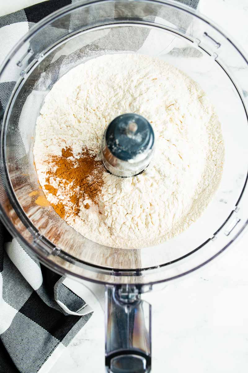 A food processer with dry ingredients for the homemade pie crust.