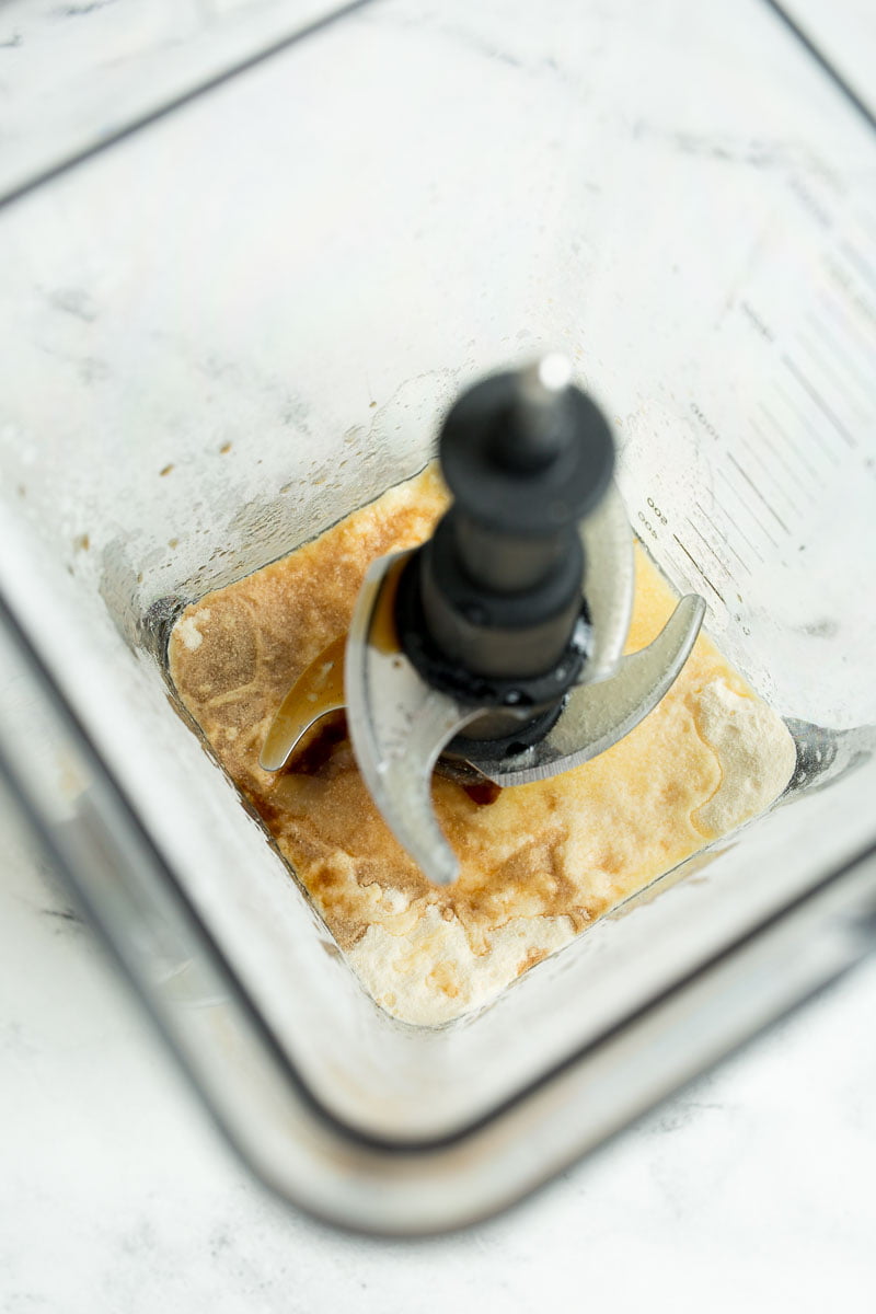Overhead view of blender with ingredients for sweetened condensed milk. 