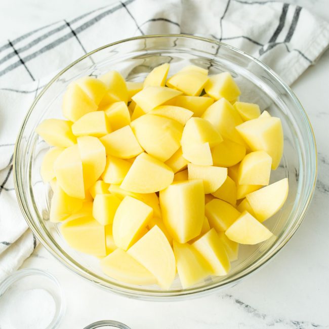 A close up image of quartered and sliced gold potatoes