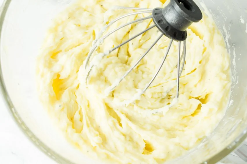 An upclose image of mashed potatoes whipped with a kitchen aid whisk attachment