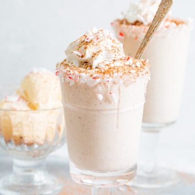 A side view of peppermint almond mocha milkshake with a spoon and vanilla ice cream in the background