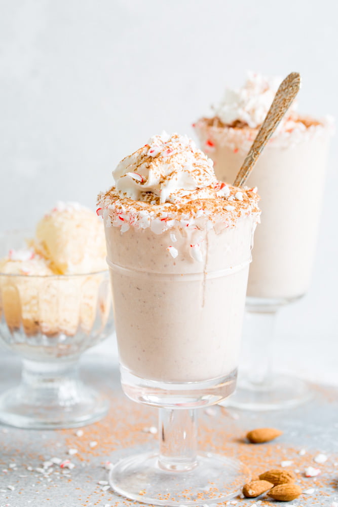 A side view of peppermint almond mocha milkshake with a spoon and vanilla ice cream in the background