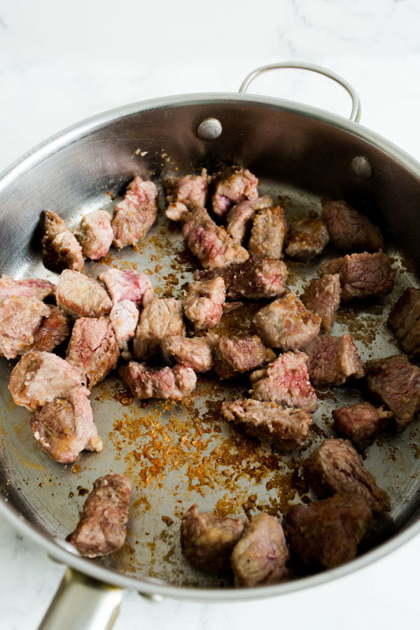 Steak being seared in a skillet